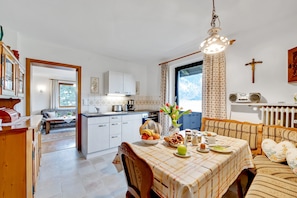 A spacious kitchen with a dining area, a sofa, and a view of the outdoors. - Apartment 1 with Mountain View, Wi-Fi & Balcony (Grassau)