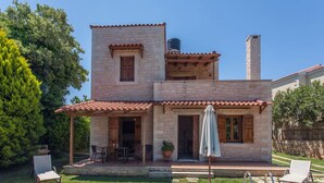 Una casa in pietra a due piani con piscina, area relax all'aperto e un pergolato.