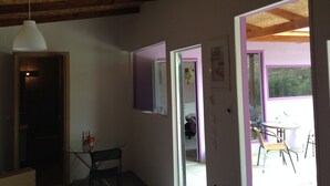An interior with a wooden ceiling, a table with chairs, and a door leading to another room. - New and Colorful Studio Near Airport and Beach in Heraklion (Heraklion)