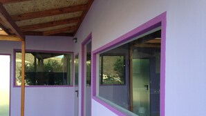 A room with purple walls, large windows with purple frames, and a wooden ceiling. - New and Colorful Studio Near Airport and Beach in Heraklion (Heraklion)