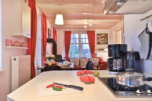 A modern kitchen with a central island, a coffee maker, and a stove.