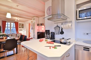 A modern kitchen with a central island, stainless steel appliances, and a dining area with a view.