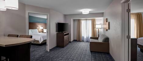 Une chambre d’hôtel avec un lit, une télévision, un bureau et un canapé.