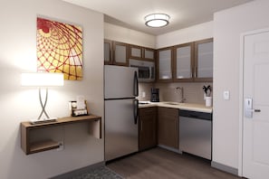 Une cuisine moderne avec des meubles en bois, un réfrigérateur en acier inoxydable, un four à micro-ondes et une machine à café.
