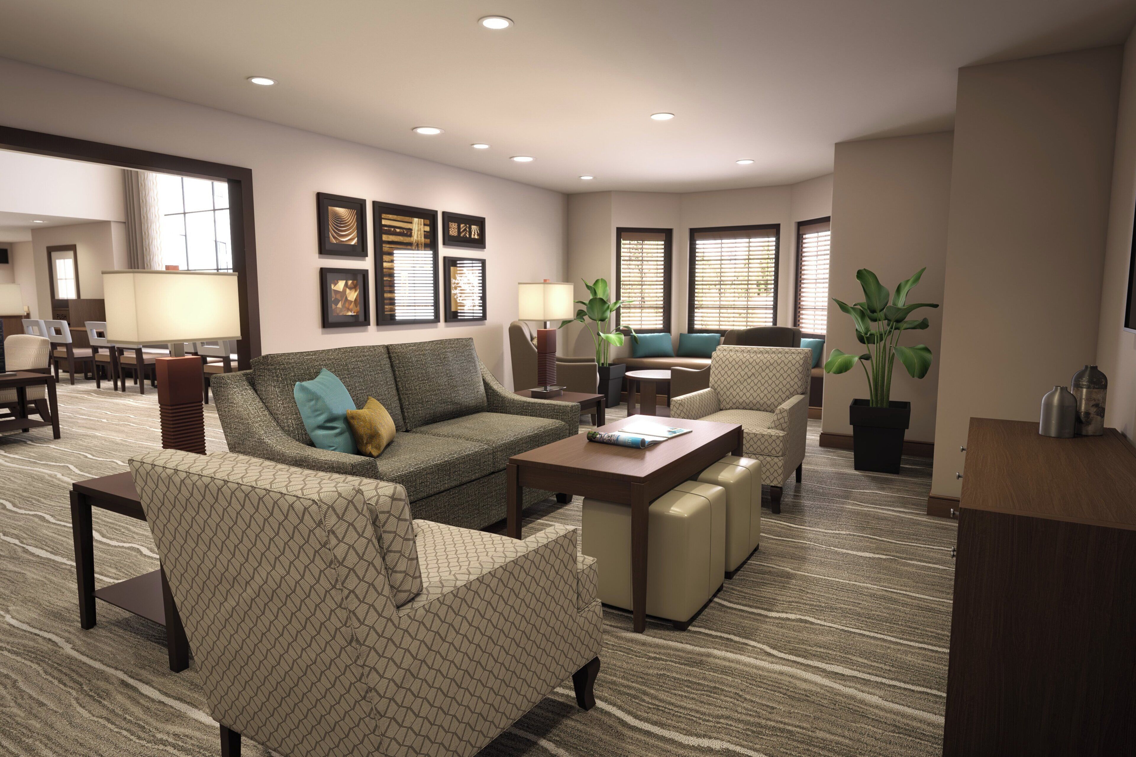 A hotel living room with a sofa, armchairs, a coffee table, and a dining area in the background.