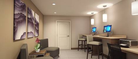 Quarto de hotel com escrivaninha, duas cadeiras, uma mesinha com uma planta e obras de arte na parede.