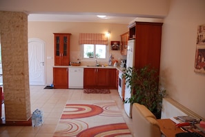 Kitchen area with a clean layout, wooden cabinetry, and a refrigerator with ice maker.