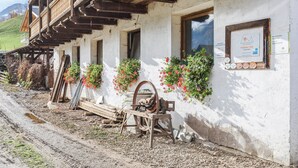Ein rustikales Gebäude mit hölzernen Balkonen, einem Fenster mit einem Schild und Blumenkästen an der Wand.