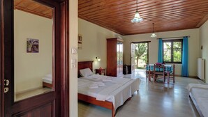 Une pièce spacieuse avec un plafond en bois, un grand lit, une table à manger avec des chaises et une vue par la fenêtre.