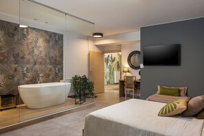 A modern bathroom with a freestanding bathtub, a mirror, and a wall-mounted TV. - Olivenest Chania Executive Villa (Chania)
