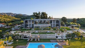 Un complexe hôtelier moderne doté d’une piscine, d’un espace extérieur aménagé et offrant une vue sur les montagnes.