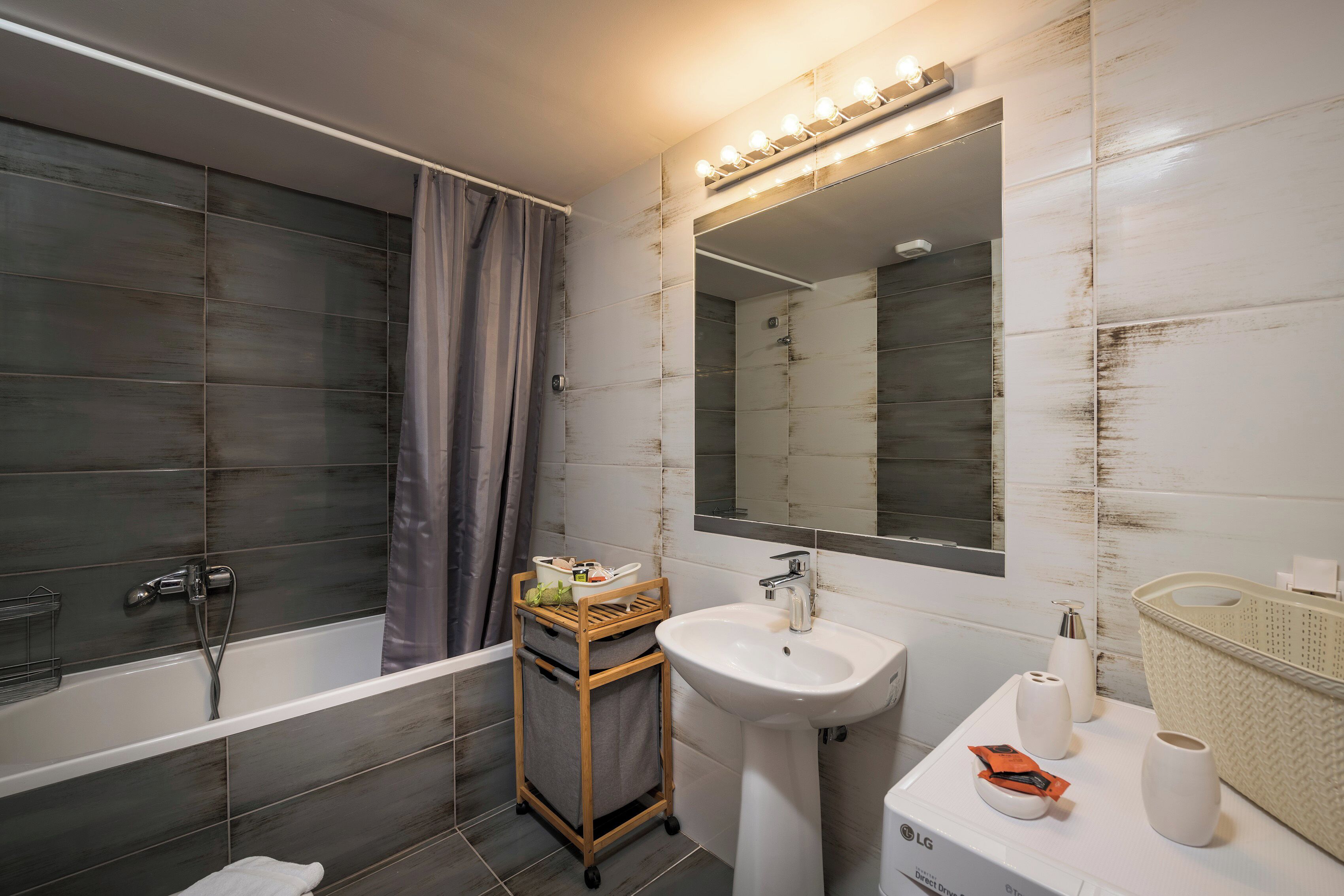 A modern bathroom with a bathtub, a sink, and a vanity.