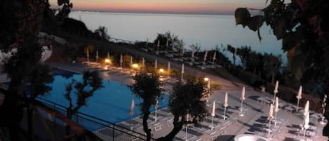 Una piscina al aire libre de temporada, sombrillas