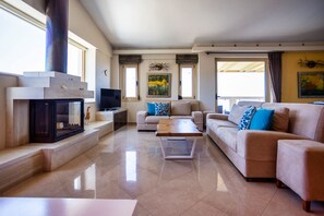 Cozy living room with a fireplace, flat-screen TV, and comfortable seating area.
