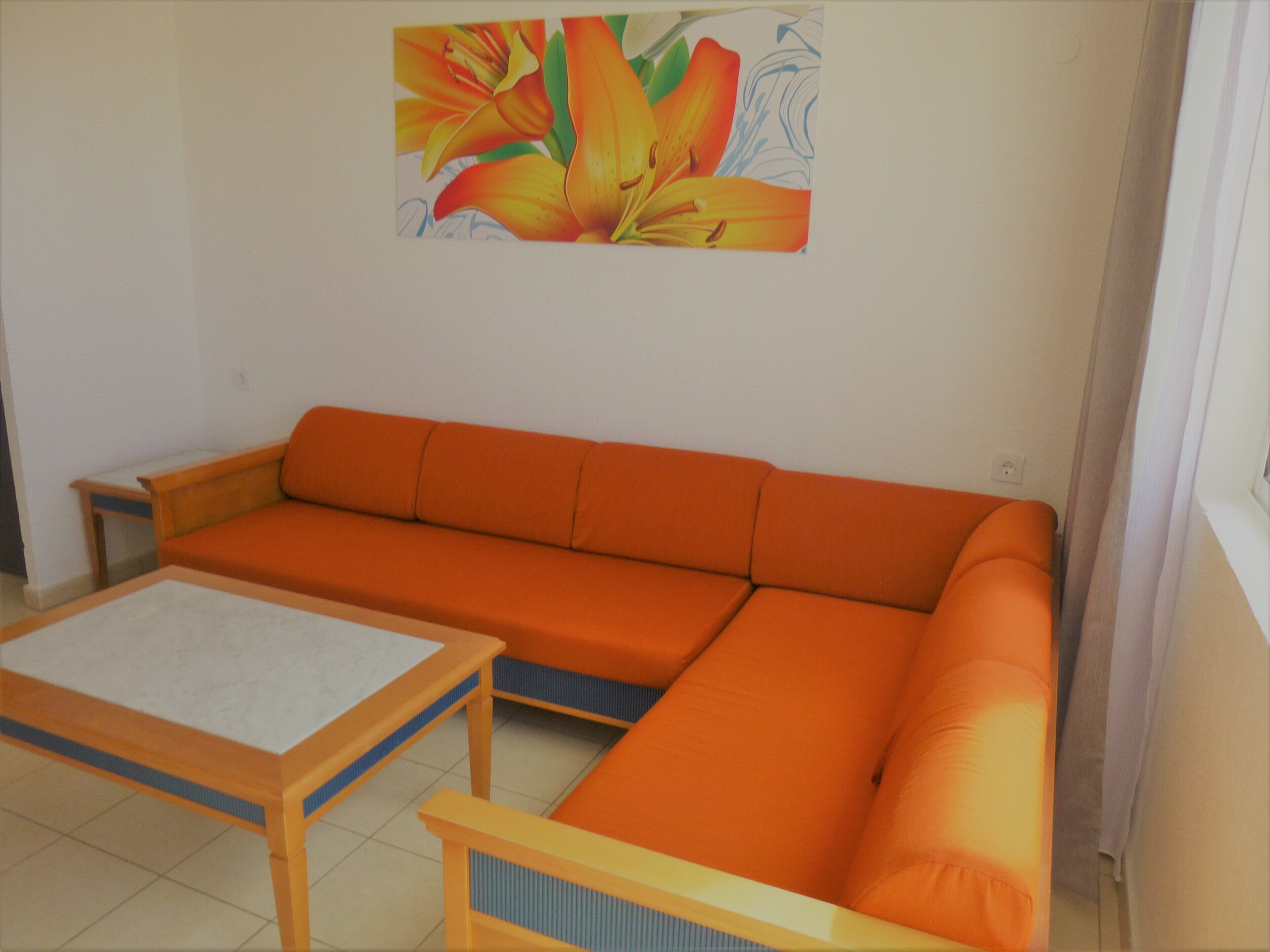 Una habitación con un sofá, una mesita y un cuadro en la pared.