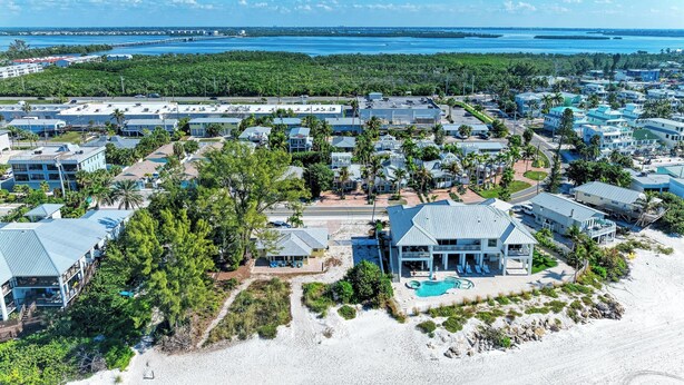 A coastal resort with multiple buildings, a beach, and a clear view of the ocean.