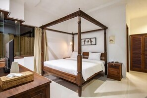 Una cama con dosel sobre una estructura de madera, una mesita de noche con lámpara y un cuadro enmarcado en la pared.