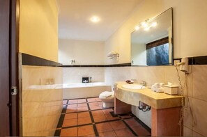 Un baño con bañera, inodoro y lavamanos.