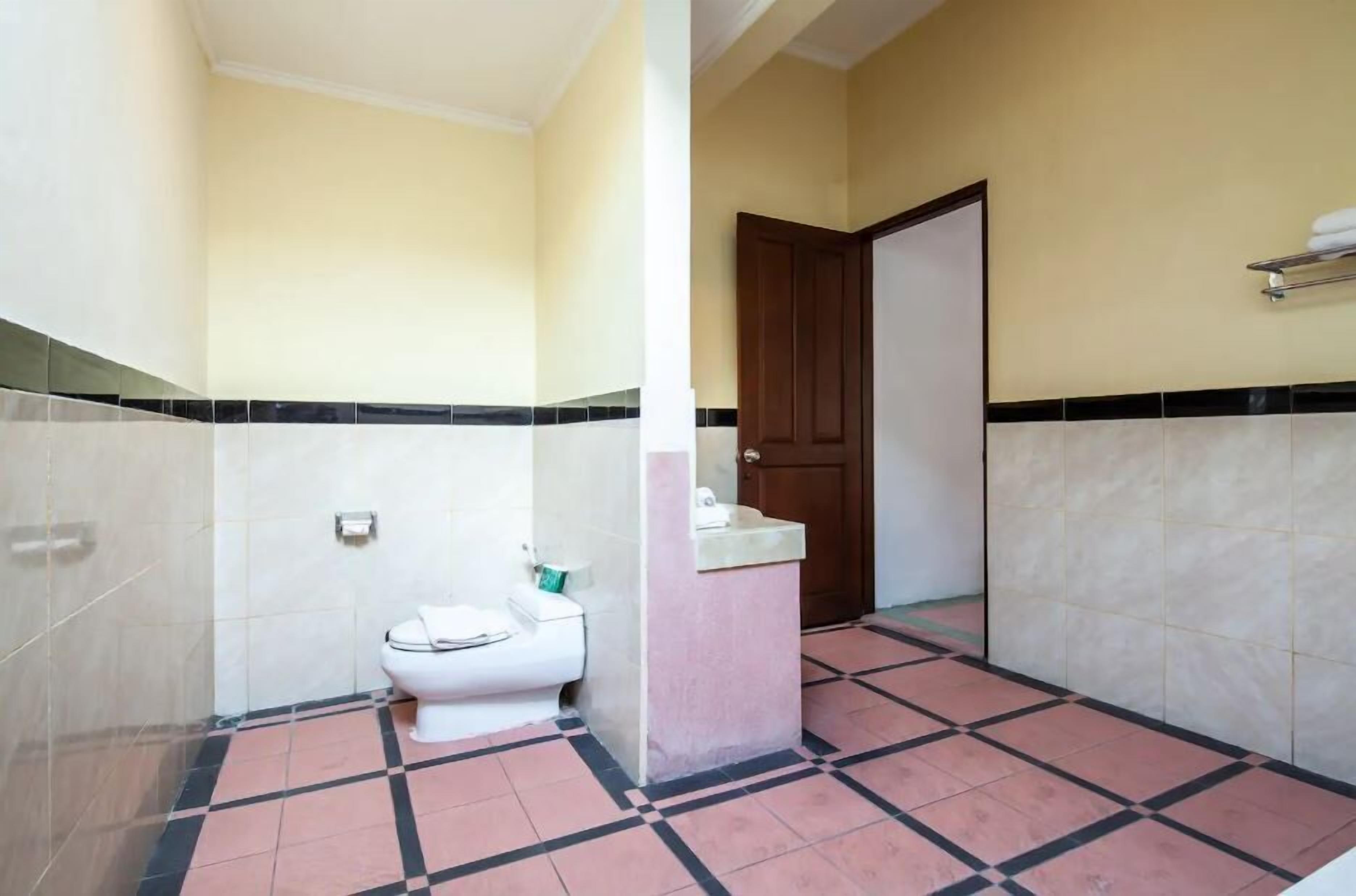 Een badkamer met toilet, wastafel en douche.