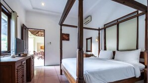 A four-poster bed with white linens, a wooden desk with a television, and a large mirror. - PB - 7BR - V5 & V1 7BR Private Pool Villa, Walk to Seminyak Beach (Seminyak)