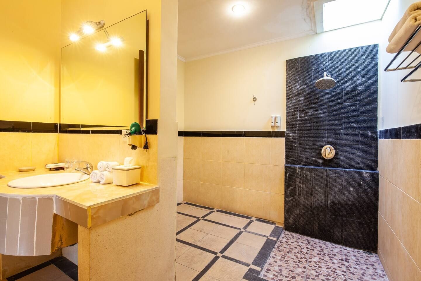 Baño con lavamanos, espejo y ducha.