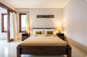 Une chambre avec un grand lit, deux tables de chevet, une fenêtre avec des rideaux et une œuvre d’art accrochée au mur.