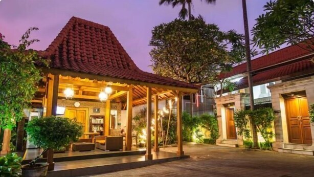 A traditional-style building with a tiled roof, a covered outdoor seating area, and a well-lit interior. - SMV- 2BedGRDN - V7 · 2BR Garden Villa Walk to shops and Beach Legian (Legian)