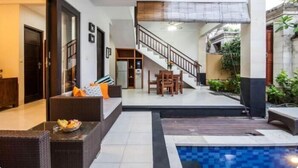 Un intérieur moderne avec un escalier, une piscine et un coin repas.
