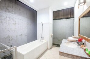 Une salle de bain avec une baignoire, un lavabo et un miroir.