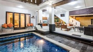 Ein modernes Hotelinnere mit Schwimmbad, Lounges und einer Treppe zu den oberen Etagen.