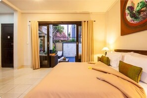 A hotel room with a large bed, a balcony with curtains, a painting on the wall, and a view of the outside.