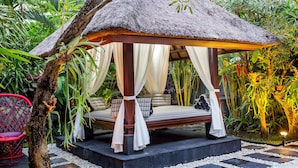 A thatched-roof gazebo with a bed and white curtains, surrounded by lush greenery. - Samudra · 3BR Luxury Private Pool Villa Bali (Kerobokan)