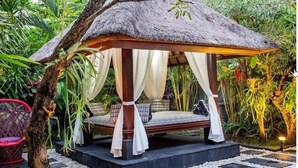 A thatched-roof gazebo with a bed, surrounded by lush greenery. - Samudra · 6BR Luxury Family Pool Villa Umalas Bali (Kerobokan)