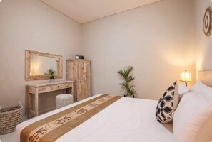 Une chambre à coucher avec un lit, une commode en bois, un miroir et une lampe de chevet.