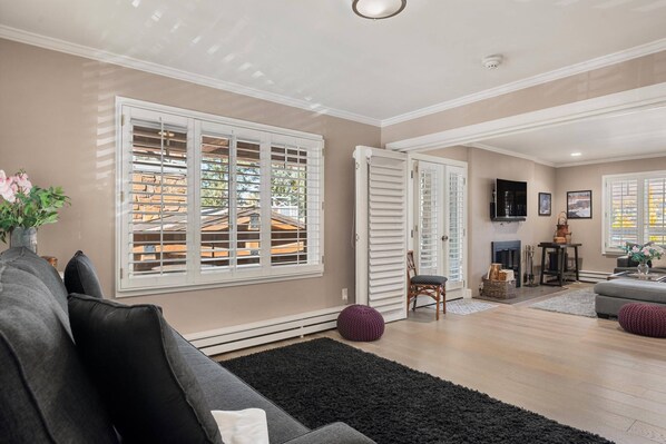 A living room with a sofa, a black rug, and a fireplace. - Aspen Condo 1.5 Blocks to Town. Balcony. Outdoor Pool. Sleeping Den w/Sofa Bed, 3 Bathrooms, Gas FP (Aspen)