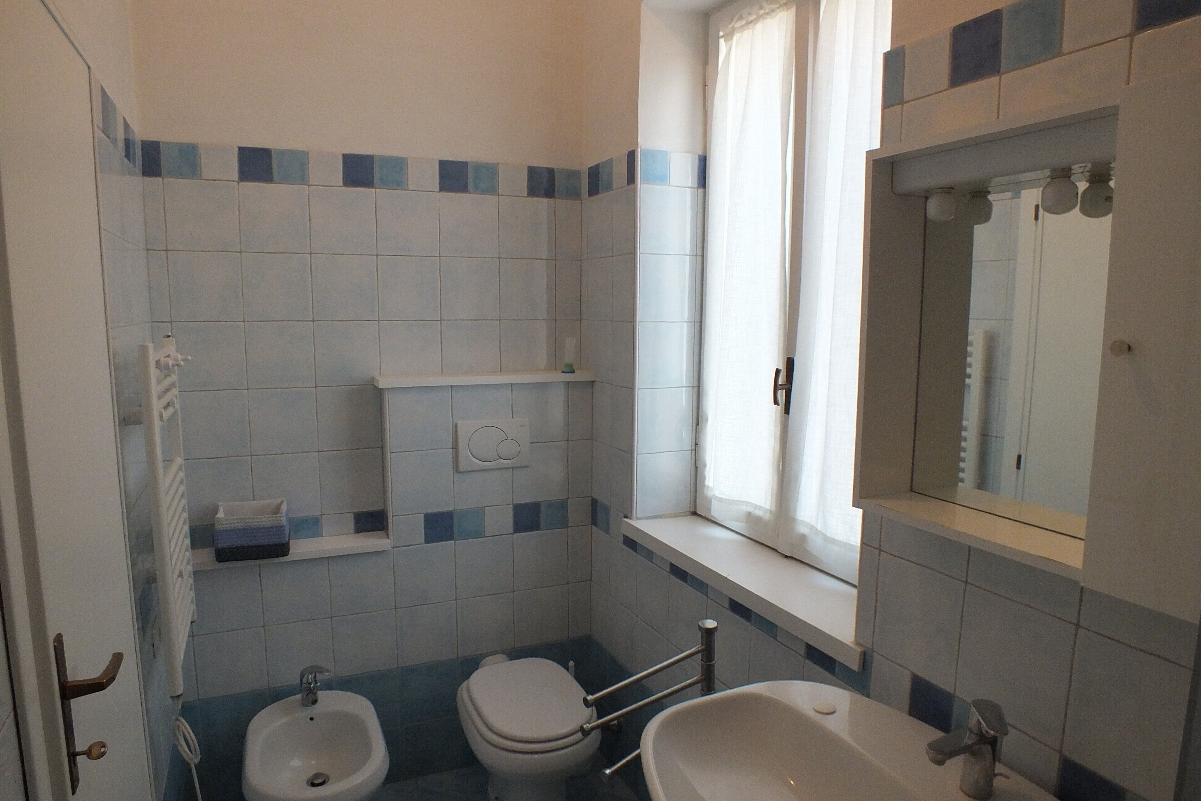 A bathroom with a toilet, bidet, and bathtub.