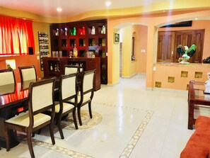 Relax in this stylish living area with a dining table, bar, and comfortable seating.