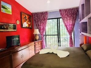 Relax in this inviting room featuring a comfortable bed, a large window, and a television.