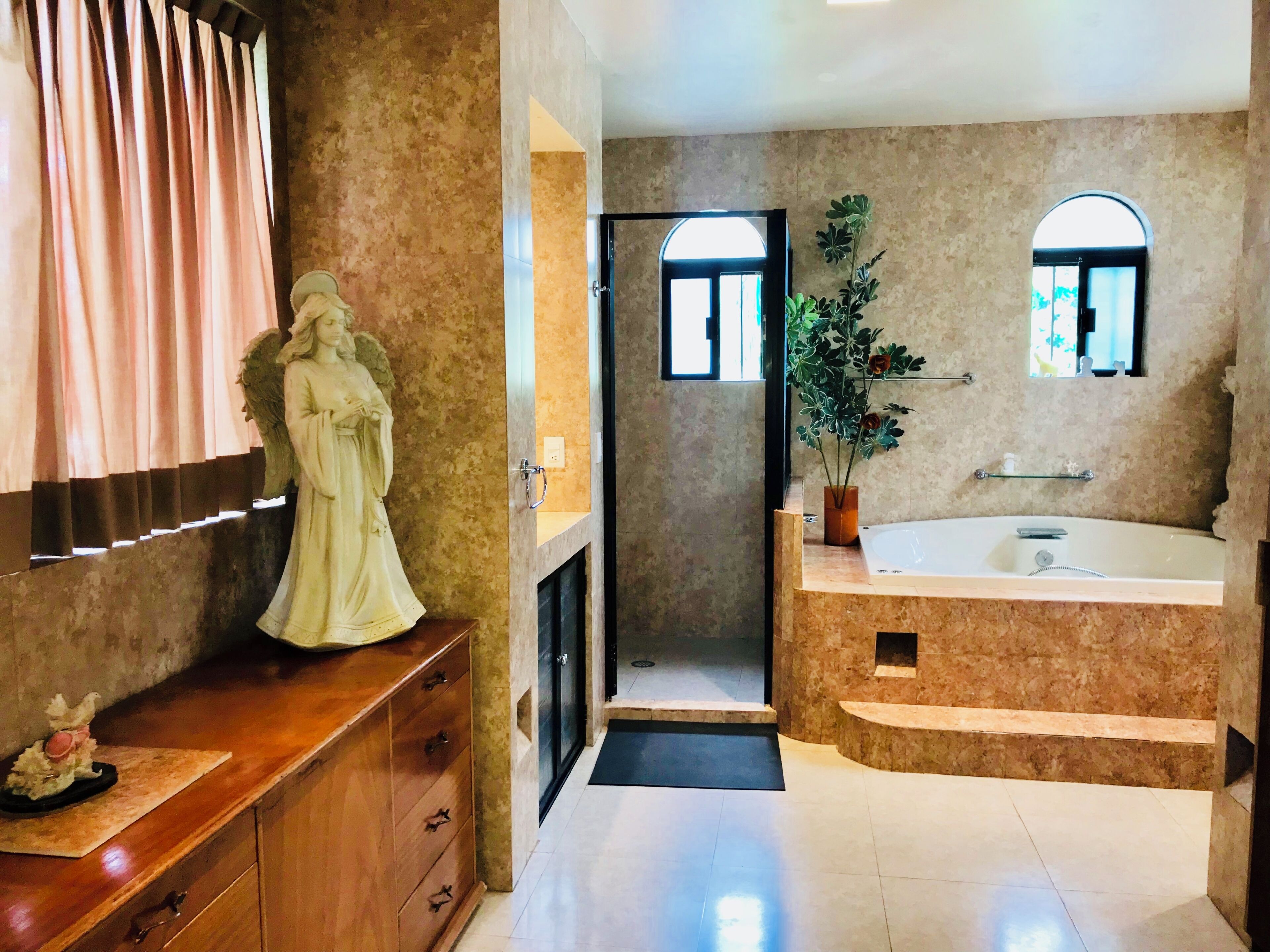 A bathroom with a marble sink, vanity, and a statue.