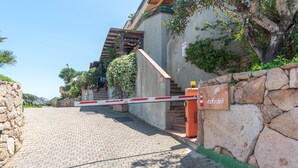 A gated entrance with a stone wall, a staircase, and a sign that reads 'Astodeli.' - Apartment with Panoramic Sea View and Terrace; Pets Allowed (Palau)