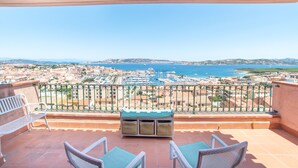A balcony with a view of a marina and coastal town. - Apartment with Panoramic Sea View and Terrace; Pets Allowed (Palau)