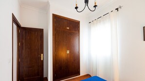 A bedroom with a bed, a wardrobe, and a door.
