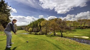 A golf course with a pond, trees, and a clear sky. - Oakridge, St Mellion, Cornwall + 2 Leisure Passes (Saltash)