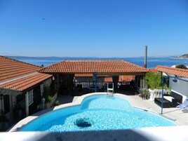 Una piscina al aire libre de temporada, sillones reclinables de piscina