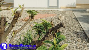 A modern white building with a tiled roof, a small window, and a door. - Pefki Beach Front Villa (Rhodes)