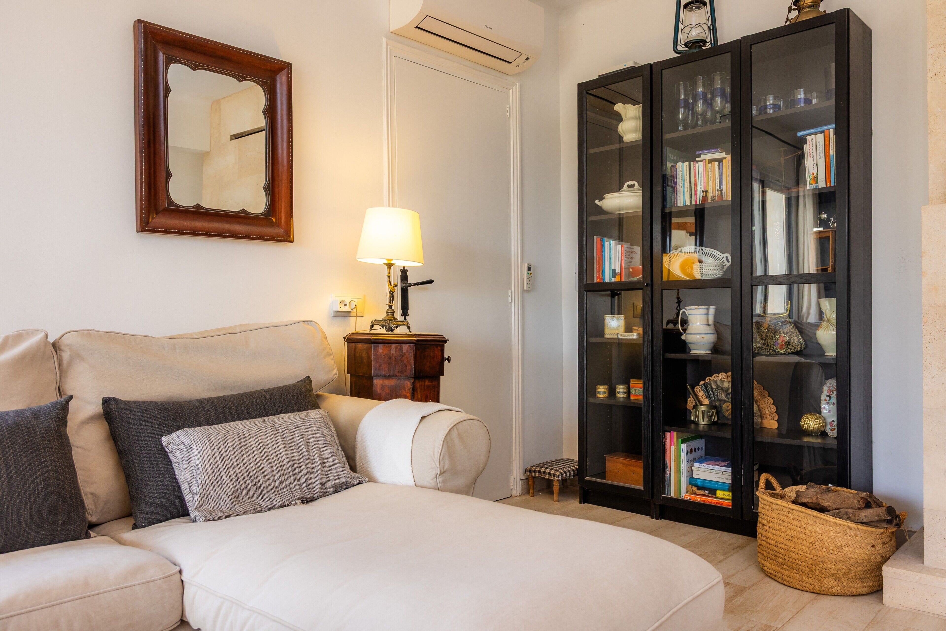 A bedroom with a bed, bedside table, lamp, and a bookshelf.