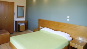 A hotel room with a bed, a wooden wardrobe, a bedside table, and a small desk with a chair. - Villa Olive Grove,superior Studio (Rhodes)