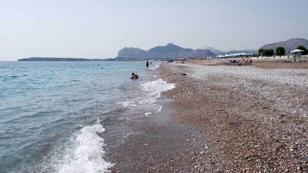 A pebbled beach with clear water, distant mountains, and a few people. - Villa Olive Grove,superior Studio (Rhodes)
