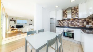 A modern kitchen with white cabinets, a tiled backsplash, and a built-in oven. - Amazing penthouse with stunning views of the sea and the mountains. (Cala Millor)