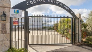 A gated entrance with a sign for 'Cortijo Puerto Nuevo' and a 'Vivienda Rural' sign. - Holiday Home "Cortijo Rural Puerto Nuevo" with Pool, Garden, Terrace & Wi-Fi (Málaga)
